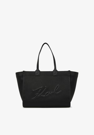 Bolso tote de textura negra con dos asas en la parte superior. Presenta el logo "Karl" en relieve en la parte frontal y acentos de hardware angulares. Material duradero.