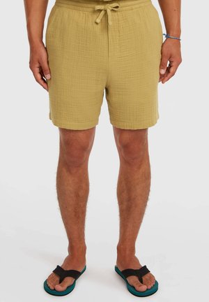 Yellow textured shorts with an elastic drawstring waistband, featuring side pockets and a relaxed fit, paired with black flip-flops.