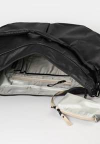 Borsa in tessuto nero con interno con zip, dotata di una fodera grigio chiaro, una tasca con zip e un piccolo portafoglio staccabile con tracolla.