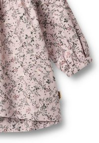 Stoff mit floralem Muster in sanftem Rosa. Langärmlig und gerafft mit einem Bündchen. Enthält kleine Blumen und Blätter in verschiedenen Farben.