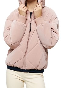 Puffjacka i ljusrosa, med ett quiltat mönster, ribbade ärmslut och en framficka med dragkedja. Huvan är delvis zipad. Mjuk, glansig textur.