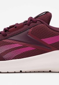 Basket de sport bordeaux avec une tige texturée, dotée d'accents brillants et de rayures diagonales roses. Semelle blanche épaisse à forme arrondie.