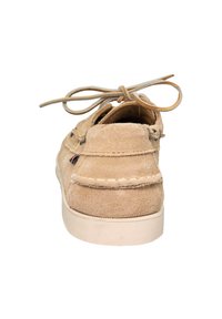 Zapato de barco de ante beige con puntera redonda, costuras decorativas y superficie texturizada. Cuenta con cordones planos y ojales de metal para el cierre.