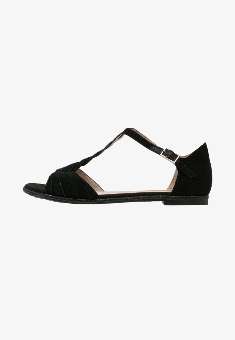 Sandale en daim noir avec bout ouvert, brides croisées, détail plissé et petite boucle de fermeture. Semelle plate, design minimaliste.
