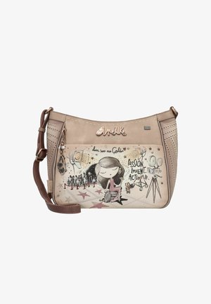 Beige Umhängetasche mit Illustration einer Frau im Rollstuhl, Filmkamera, Lichtern, Sternen und dem Text "Leidenschaft, Erfinden, Handeln."