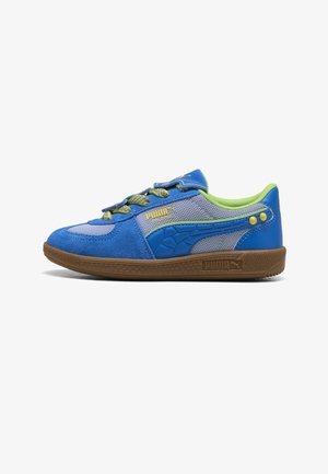Lage blauw-grijze Puma sneaker met groene voering, gele accenten, gestructureerde zool en merklogo op de zijkant.