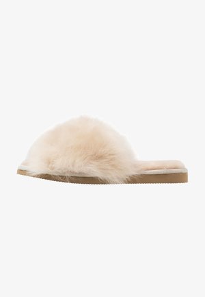 Faux fur slide slipper in light beige with a fluffy upper, soft insole, and flat tan rubber outsole. Simple design with no hardware.
