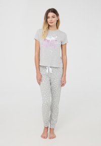 Set di pigiama grigio composto da una maglietta a maniche corte con il testo "Sweet Dreams" e una grafica di nuvole, e pantaloni aderenti con motivi a cuori bianchi.
