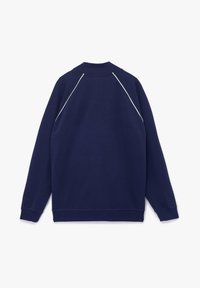 Sudadera azul marino con cuello y puños de canalé, que presenta piping blanco a lo largo de las costuras de los hombros. Fabricada con un tejido suave y texturizado.