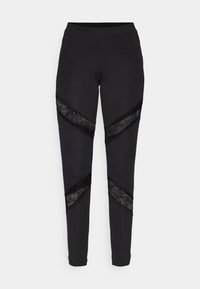 Zwarte legging met kantaccenten, met een chevron ontwerp aan de zijkanten. Gemaakt van rekbaar materiaal voor comfort en pasvorm.
