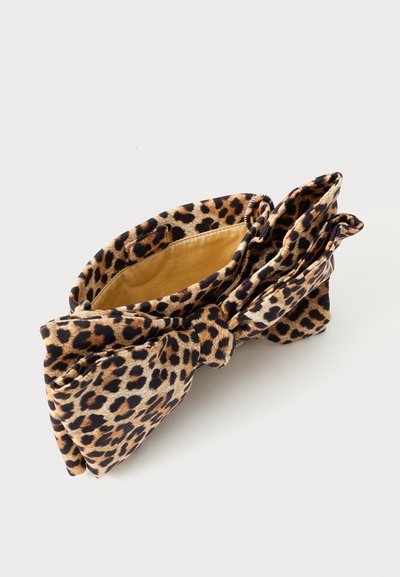 Torba iz tkanine s leopardjim vzorcem z velikim tričkom in svetlo rjavo notranjo podlogo na beli podlagi.
