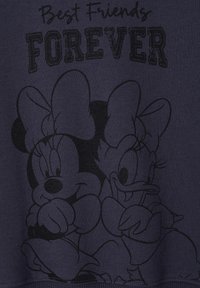 Marineblaue Stoff mit einem grafischen Druck von zwei Cartoonfiguren, Minnie Maus und Daisy Duck, mit dem Text "Beste Freunde für immer" darüber.