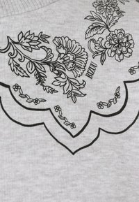 Czarny kwiatowy rysunek liniowy z liśćmi i kwiatami na jasnoszarej prążkowanej tkaninie, z wyrazem "BIZUU" napisanym wielkimi literami.