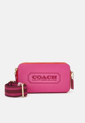 Sac bandoulière rectangulaire en cuir rose vif avec logo embossé "Coach Leatherware" et bandoulière noire amovible avec des rayures roses.