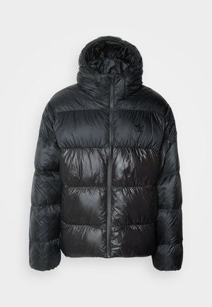 Giacca a vento nera con colletto alto e cappuccio. Presenta una texture lucida e un design a righe orizzontali con una zip centrale.