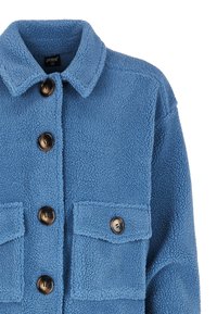 Veste en polaire bleu avec un col, des boutons à l'avant et deux poches appliquées. Material texturé et doux.