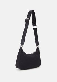 Borsa a spalla in nylon nero con forma curva, chiusura a zip e tracolla regolabile con logo. Texture liscia e design minimalista.