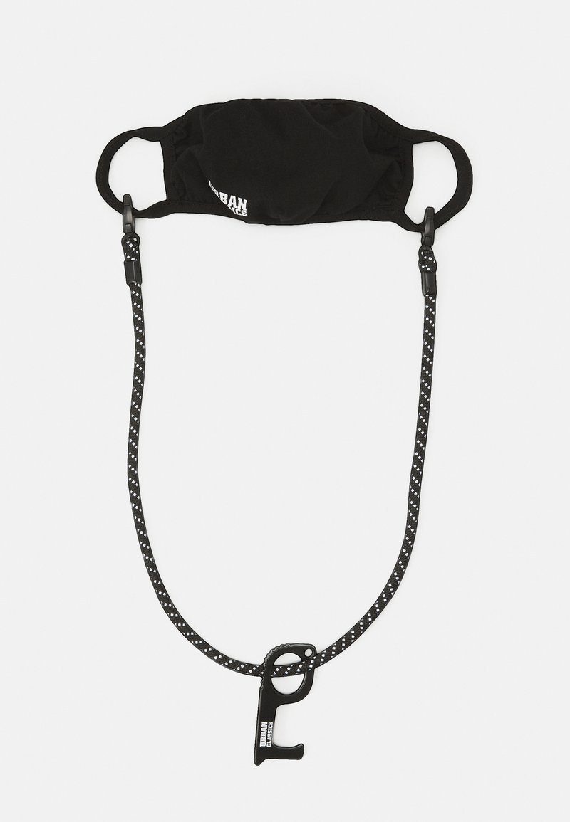 Svart tygansiktsmask med justerbara öronband, fäst vid ett band med prickigt mönster och en svart klämma för enkel användning.