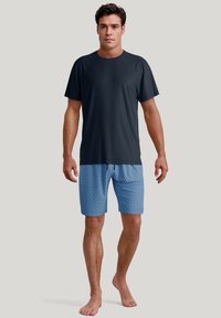 Mannelijke sportset bestaande uit een zwart T-shirt met korte mouwen en blauwe gestreepte shorts. De shorts hebben een elastische tailleband en een trekkoorddetail.