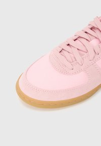 Rosa sneakers med ovandel i canvas, mockadetaljer, rund tå och gummisula. Har plana snören och en texturerad yta.