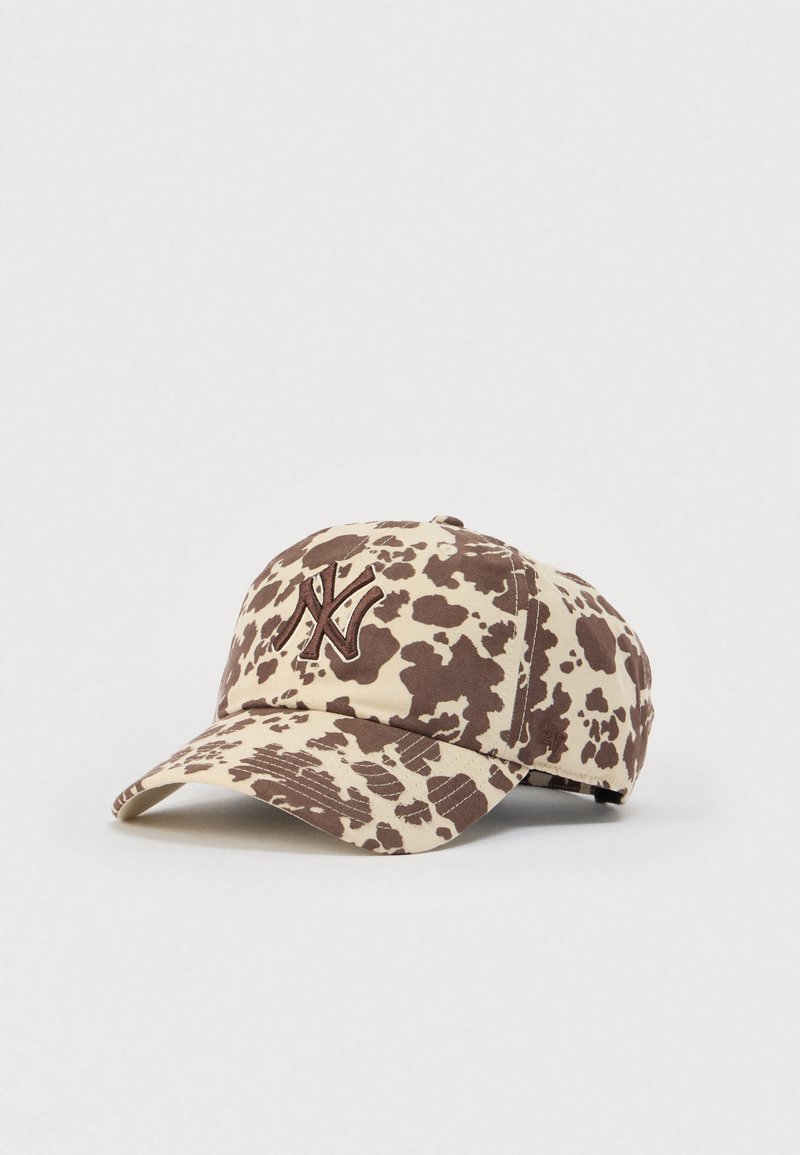 Καπέλο με μπεζ βάση και καφέ μοτίβο αγελάδας, με κεντημένο λογότυπο στο μπροστινό μέρος, καμπυλωτή γείσο και ρυθμιζόμενο λουρί στο πίσω μέρος.