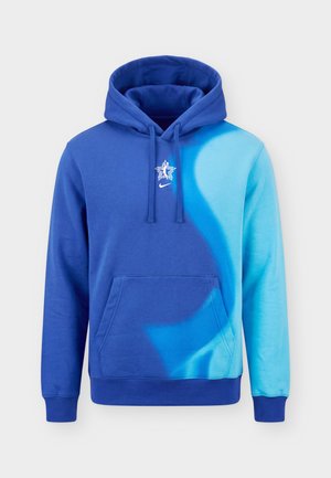 Man facing away wearing a blue Nike hoodie with "2026 WNBA All Star Basketball" text on the back.