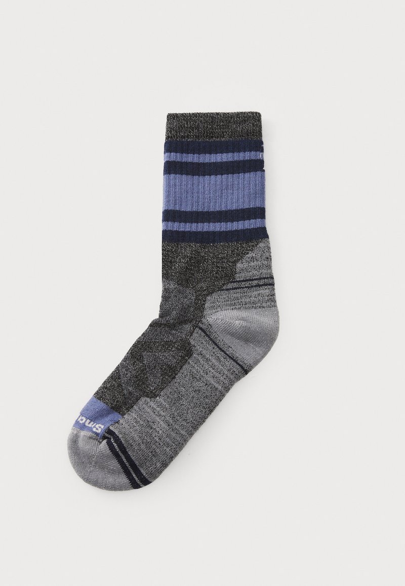 Calcetín gris con rayas horizontales en azul y azul oscuro. Presenta un patrón texturizado en la planta y un refuerzo en el talón y los dedos.