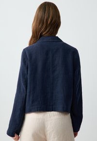 Marineblauwe linnen cropped jasje met lange mouwen en een notched kraag, met een gladde textuur en een minimalistisch ontwerp.