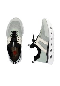 Baskets de sport légères en vert clair, noir et crème. Tige en mesh avec lacets élastiques et tirant. Semelle rembourrée avec détail de traction.