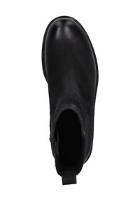 Botín de tobillo de cuero negro con puntera redondeada, paneles laterales elásticos y un tacón bajo y texturizado. Interior forrado para mayor comodidad.