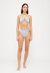 Svetlomodrý bikiny set s bandeau topom so skrúteným dizajnom a kruhovým kovovým prvkom. Vysoký pás na spodnej časti s bočnými detailami.