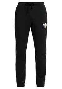 Svarta sweatpants med dragsko i midjan, vita sidostråk och en broderad logga på ena låret. Tillverkade av mjukt, lätt tyg.