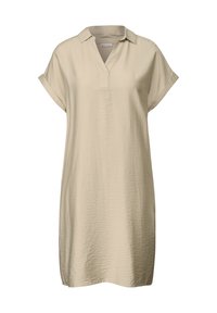 Kort, beige klänning med krage och V-ringning. Har korta uppvikta ärmar och en mjuk textur, som faller strax ovanför knäet.