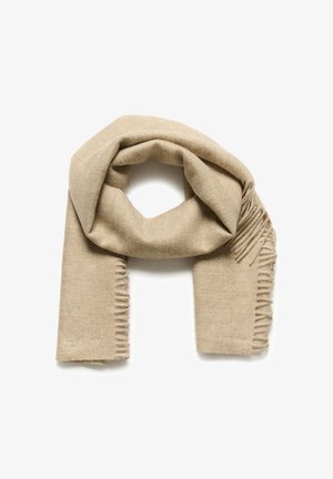 Beige villane sall, millel on pehme tekstuur, frangeeritud servad ja diskreetne tikandiga logo. Aasdisain mitmekesiste stiilide jaoks.