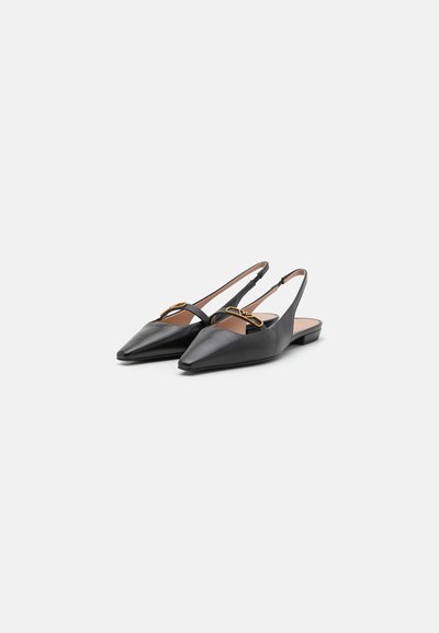 Sorte læderslingback-sko med spidse tæer, der har guldceller og en blokhæl, som fremhæver en glat tekstur og minimalistisk design.