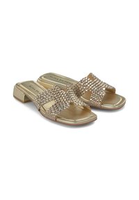 Gouden slide sandalen met een lage blokhak. Voorzien van twee kruislings verstelbare banden versierd met heldere rhinestones. Smooth metalen afwerking.