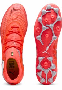 Kirkkaanpunaiset jalkapallokengät, joissa on kuvioitu verkkopäällinen, muotoillut nastat ja musta logo. Varustettu dynaamisilla nauhoilla ja hengittävällä rakenteella.