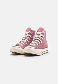 Růžové kanvasové sneakers s vysokým postavením, s krémovými tkaničkami, gumovým špičkovým krytem a texturovanou podrážkou. Obsahují stříbrné okrouhlé očko a logo na kotníku.