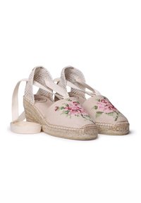 Beige espadrillos dengan bordir mawar pink. Memiliki bagian atas kanvas anyaman, sol tali jute, dan ikatan satin di pergelangan kaki. Desain datar dengan ujung bulat.