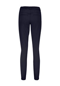 Mørkeblå bukser med elastisk talje, som har en glat tekstur, tætsiddende pasform og to baglommer. Ingen synlig hardware eller mønstre.