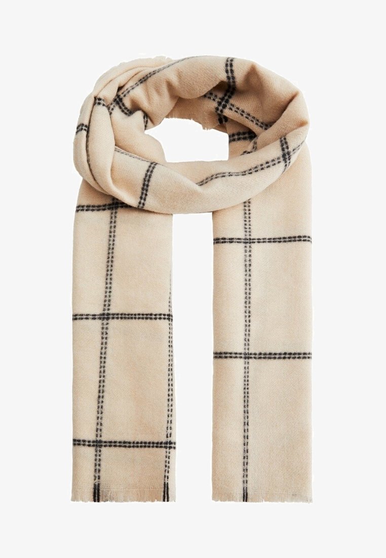 Écharpe en laine beige à motif à carreaux noirs, extrémités frangées, disposée en boucle lâche sur un fond blanc.