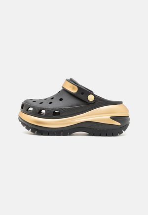 Zwart-bruine slip-on klomp met ventilatiegaten, verstelbare riem en dikke, gestructureerde zool voor grip en comfort.