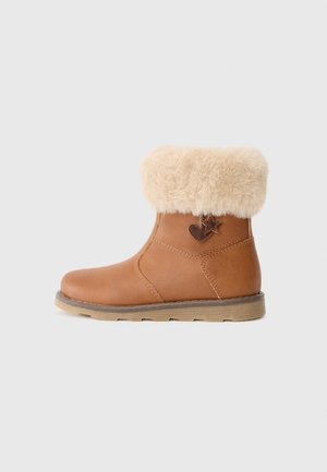 Brown ankle boot with a fluffy beige faux fur cuff, featuring a leather body, stitched detailing, and a decorative heart-shaped accent.