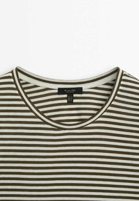 Gestreiftes T-Shirt mit Rundhalsausschnitt, das abwechselnd braune und weiße Streifen aufweist, aus weichem Stoff gefertigt ist und ein Etikett am Kragen hat.