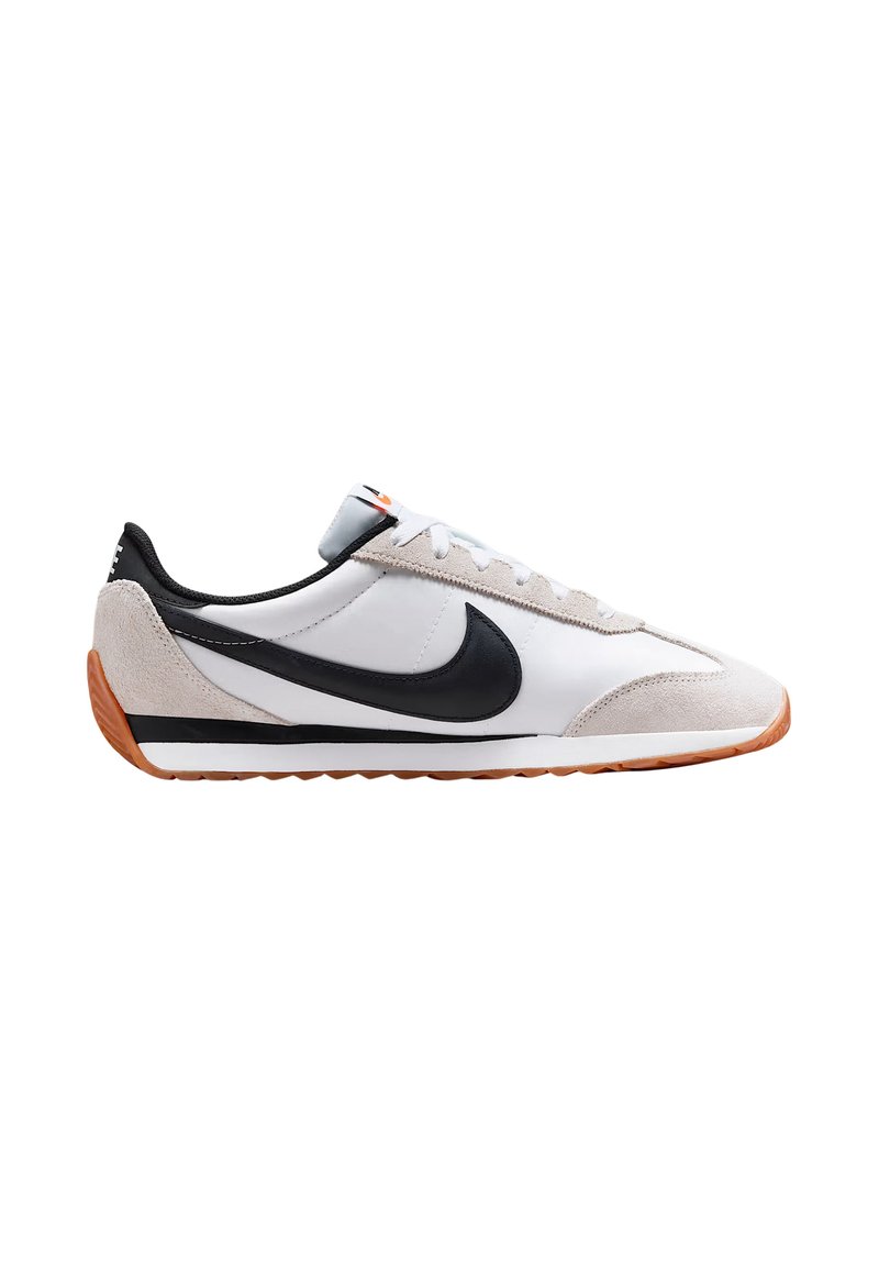Zapatilla deportiva blanca y gris con acentos negros, materiales de ante y cuero, una suela texturizada y un logo de swoosh negro en el lateral.