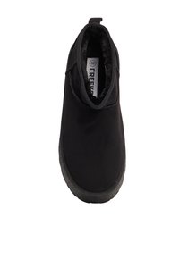 Zapato negro tipo slip-on con un suave forro interior de piel, color elástico en el cuello y suela de goma texturizada. Diseño simple, sin herrajes visibles.