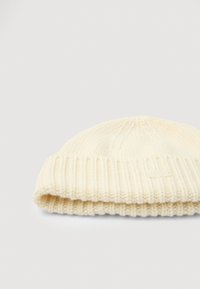 Kremowa, dziana czapka beanie z prążkowaną fakturą i podwiniętym brzegiem, z małym logo z boku, zaprojektowana dla ciepła i komfortu.