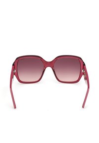 Lunettes de soleil carrées avec des montures rouges brillantes et des verres dégradés rose foncé, vue de face sur fond blanc.