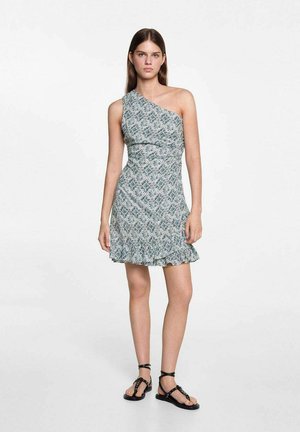 Haljina s jednim ramenom u svijetlozelenoj tkanini s uzorkom, s volanima na rubu, koja ima prilagođenu siluetu i suptilnu teksturu. Crne sandale s trakama.