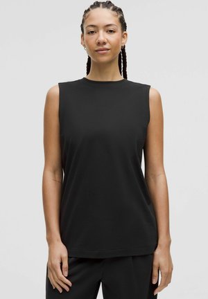 Zwarte mouwloze top met een ronde hals, gemaakt van zachte stof. Rechte snit met een zijsplit, minimalistisch design en zonder zichtbare patronen.
